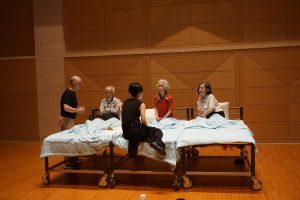 actors around bed rehearsing