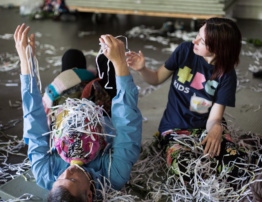 man lying on floor with shredded paper