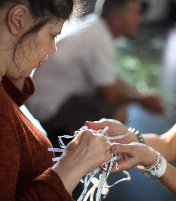 two women touch feeling shredded paper