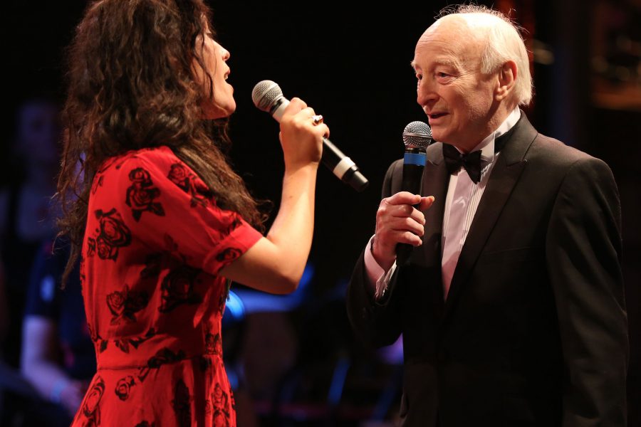 Man and women sing with microphones