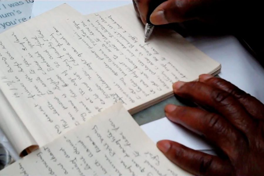 A close up of a hand writing in a notebook.