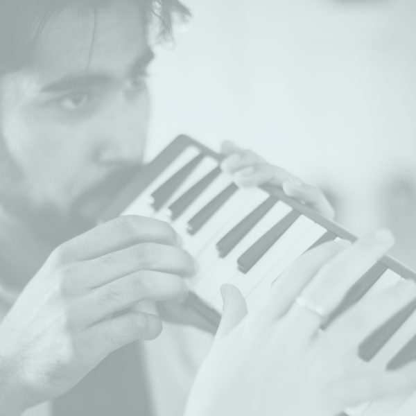 A man playing a melodica instrument.