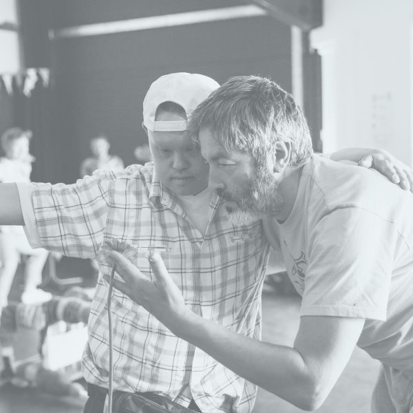 Two men dancing with their arms over each others' shoulders.