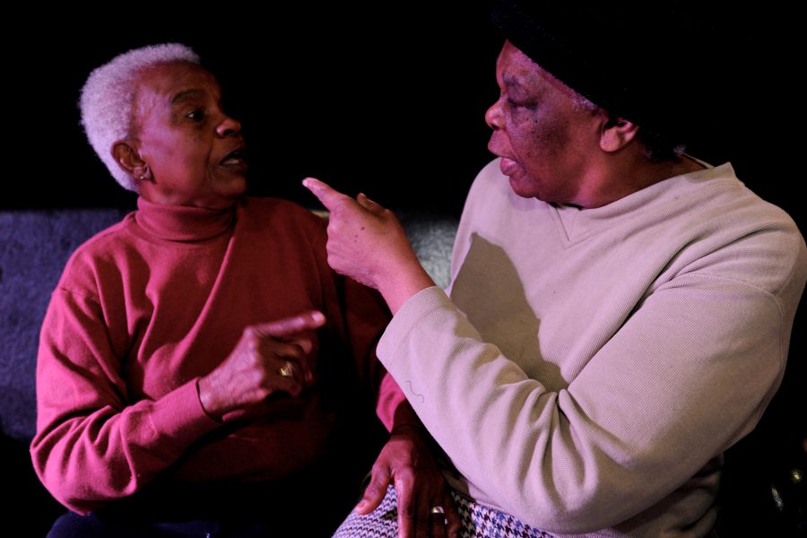 Two women pointing at each other.