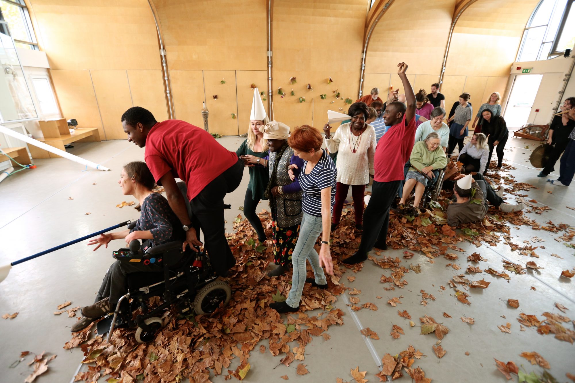 A line of people among autumn leaves on the floor