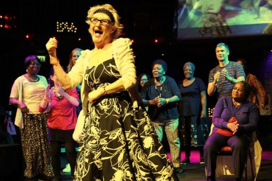 Woman dancing and laughing with others watching