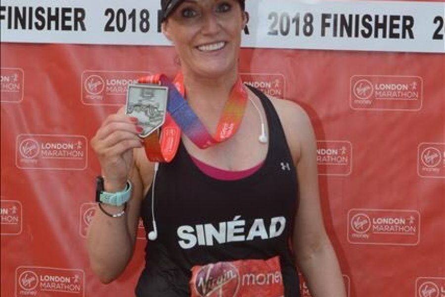 marathon runner holding medal