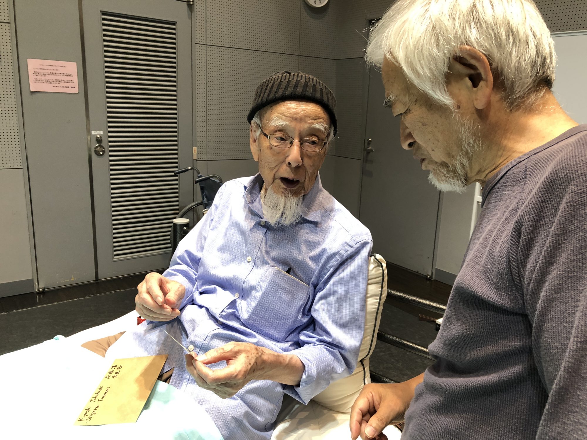 older Man in bed, director standing nearby