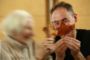 Man with a leaf smiling and woman laughing