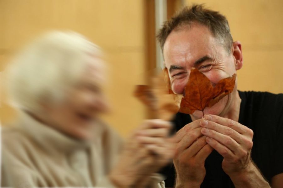 Man with a leaf smiling and woman laughing