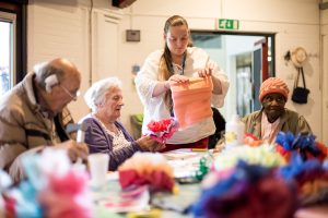 older people making paper flowers