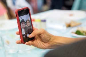 hand holding phone which has image of a man and woman on it