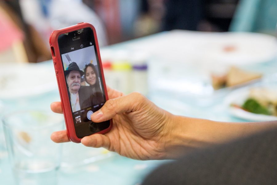 hand holding phone which has image of a man and woman on it