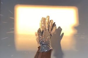 hands with glitter gloves in a square of light
