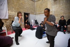 Group of people performing individually and together in a large room