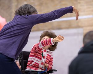 two people on in a wheelchair moving their arms