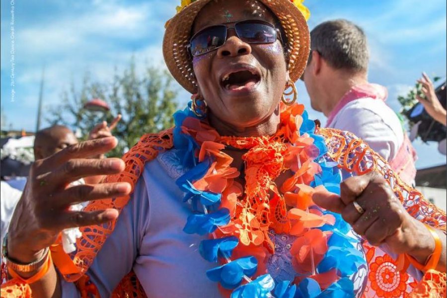 woman with hat and garlands smiling outside