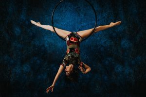 Woman doing acrobatics, suspended upside down from a hoop