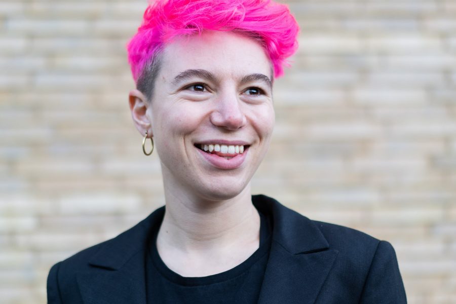 portrait of Lily Ash Sakula, a white person with short, dyed pink hair