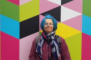 Portrait of Christine against a bright pattern background